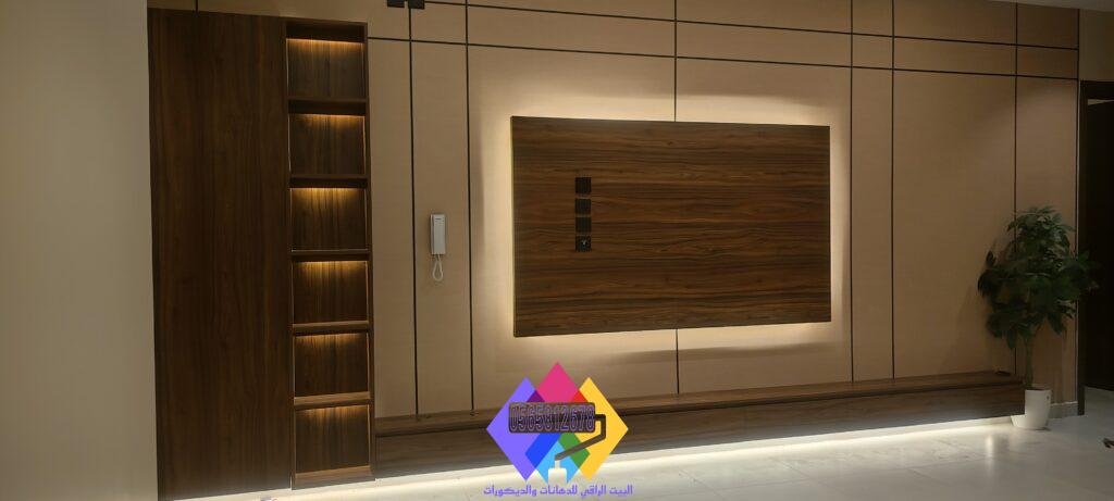 صورة لديكور شاشة فاخر في صالة استقبال، الجدار مغطى بألواح خشبية داكنة مع خطوط نحاسية